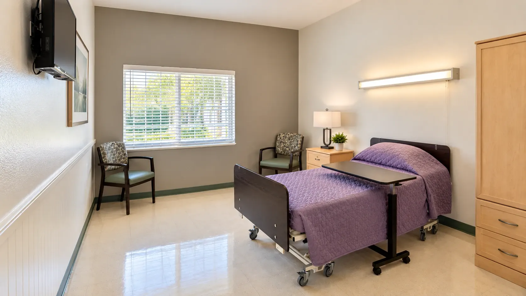 A resident room at Vivo Healthcare Harbourwood, with a bed, armchairs and a wardrobe