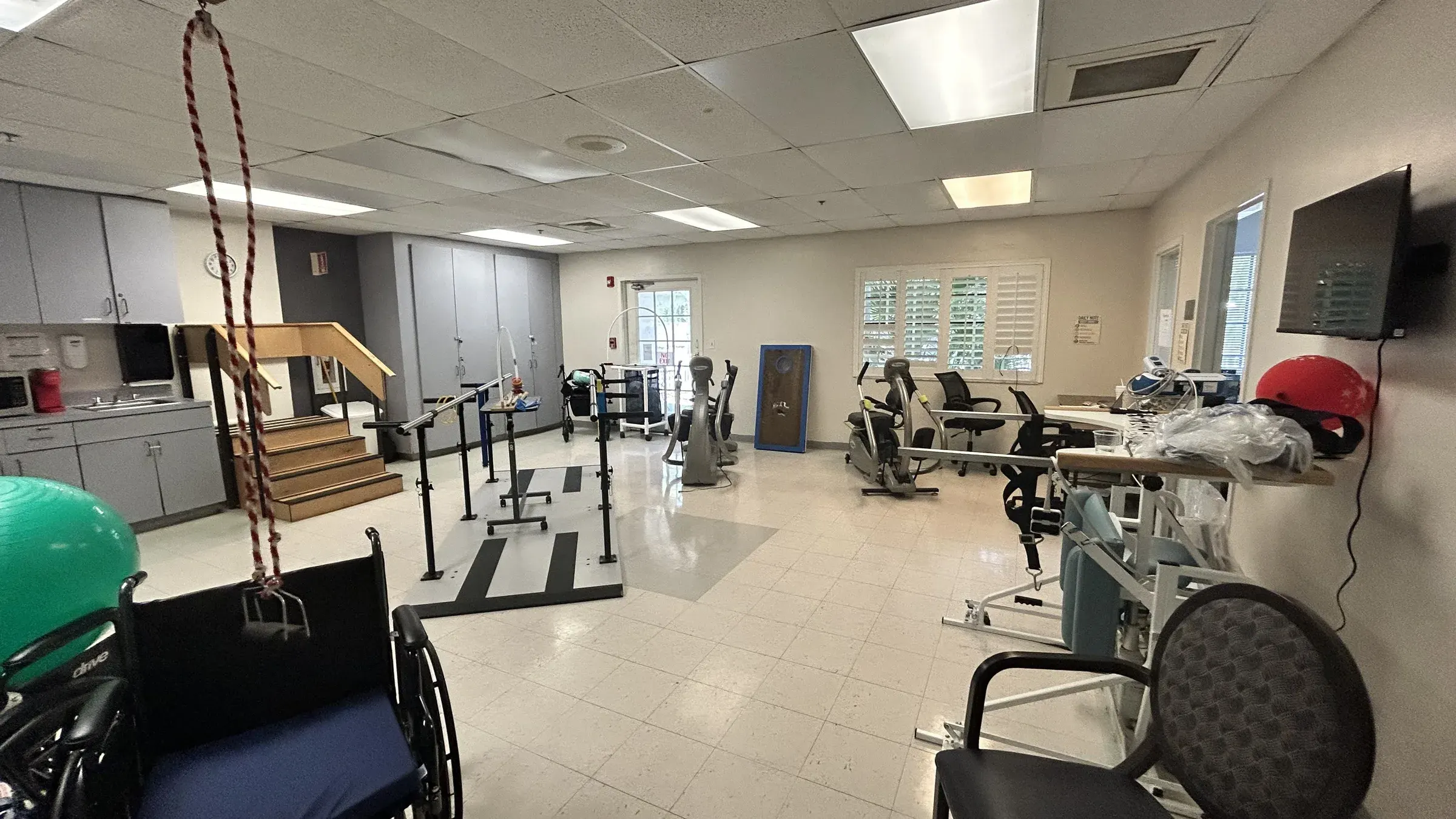 The therapy gym at Vivo Healthcare Harbourwood, with training stairs and parallel bars